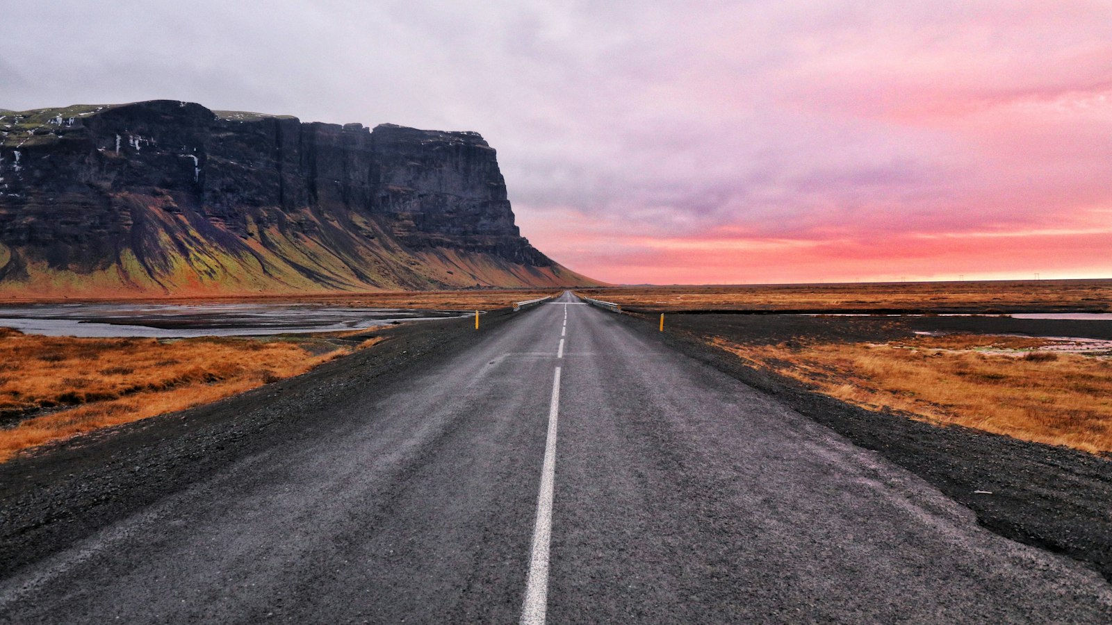 Empty road beneath cliffs