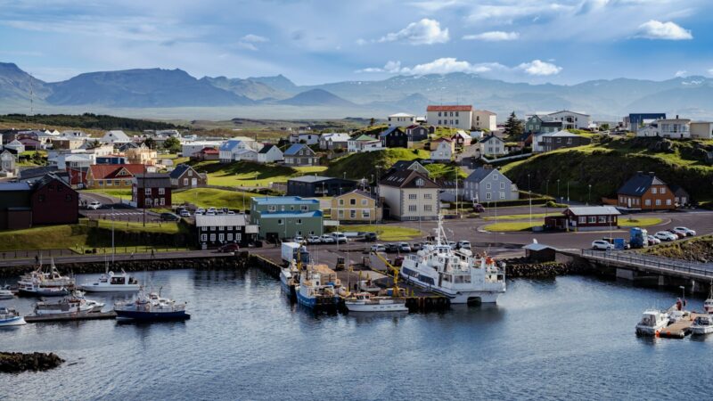 Harbour full of boats below a green hillside