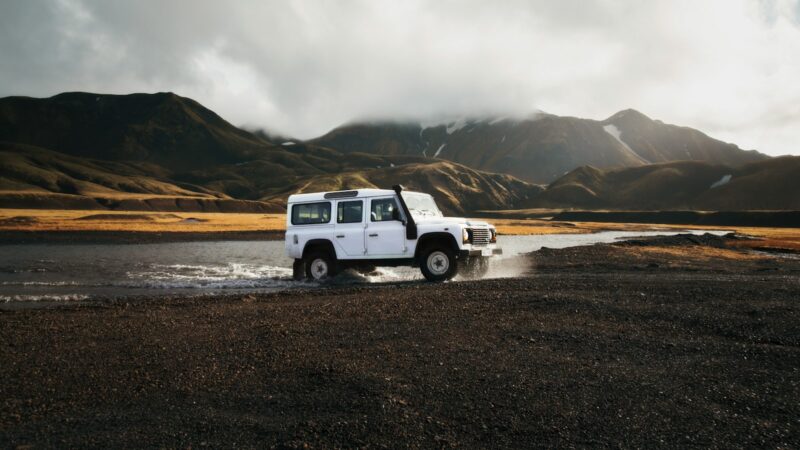 A four-wheel-drive crossing a highland river