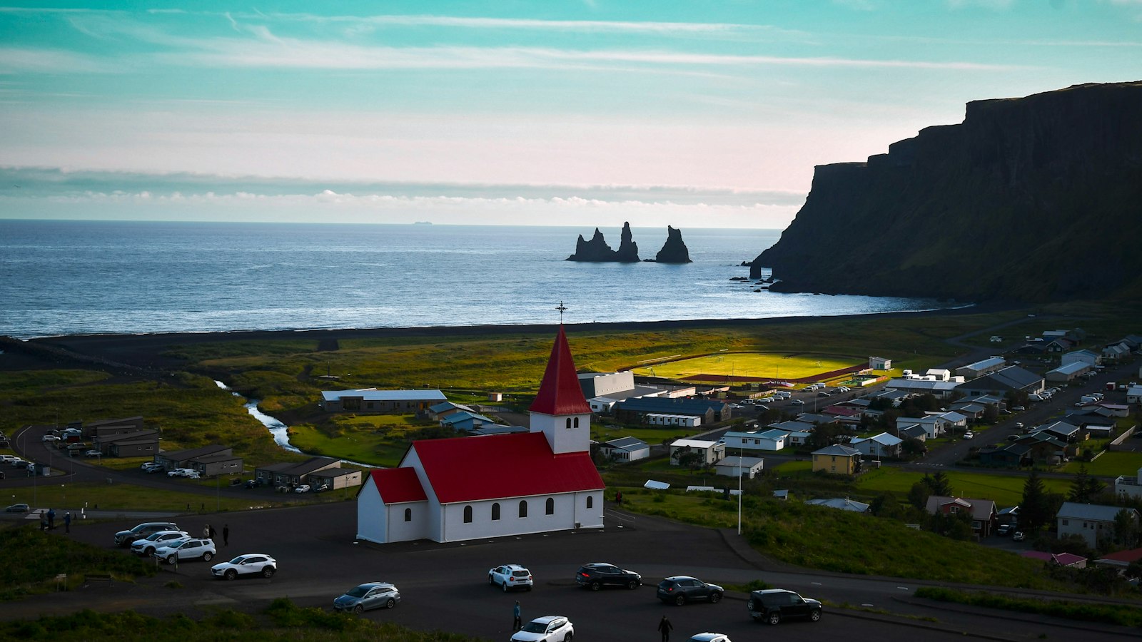Small village with a red-roofed church by the ocean