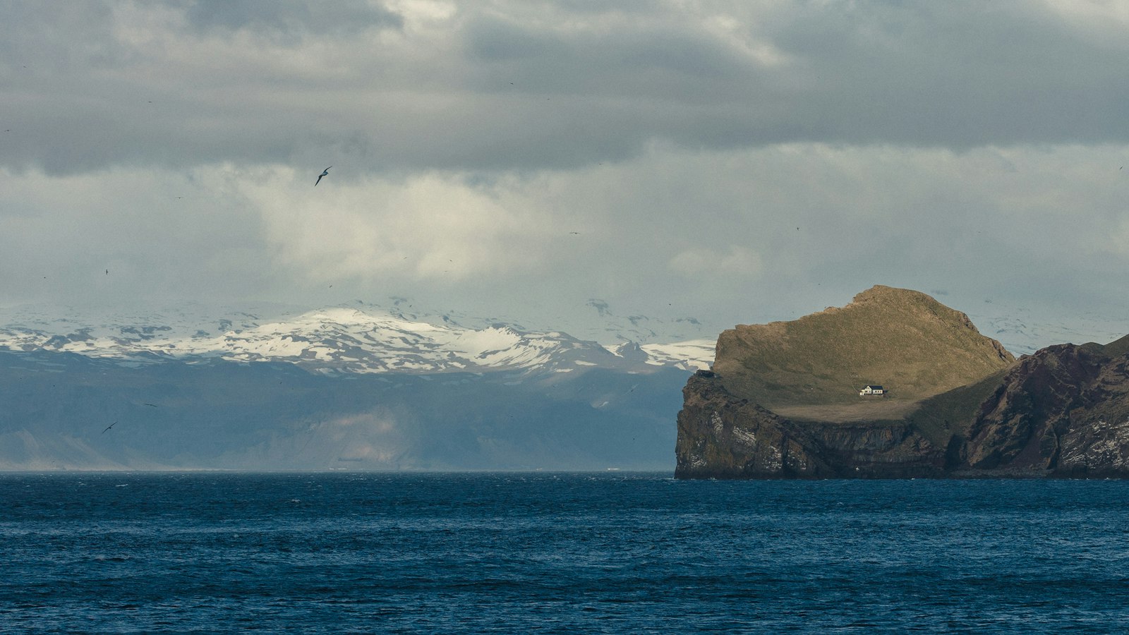 Vestmannaeyjar islands with the snow-capped south coast behind