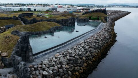 A geothermal bathing pool by a river from above