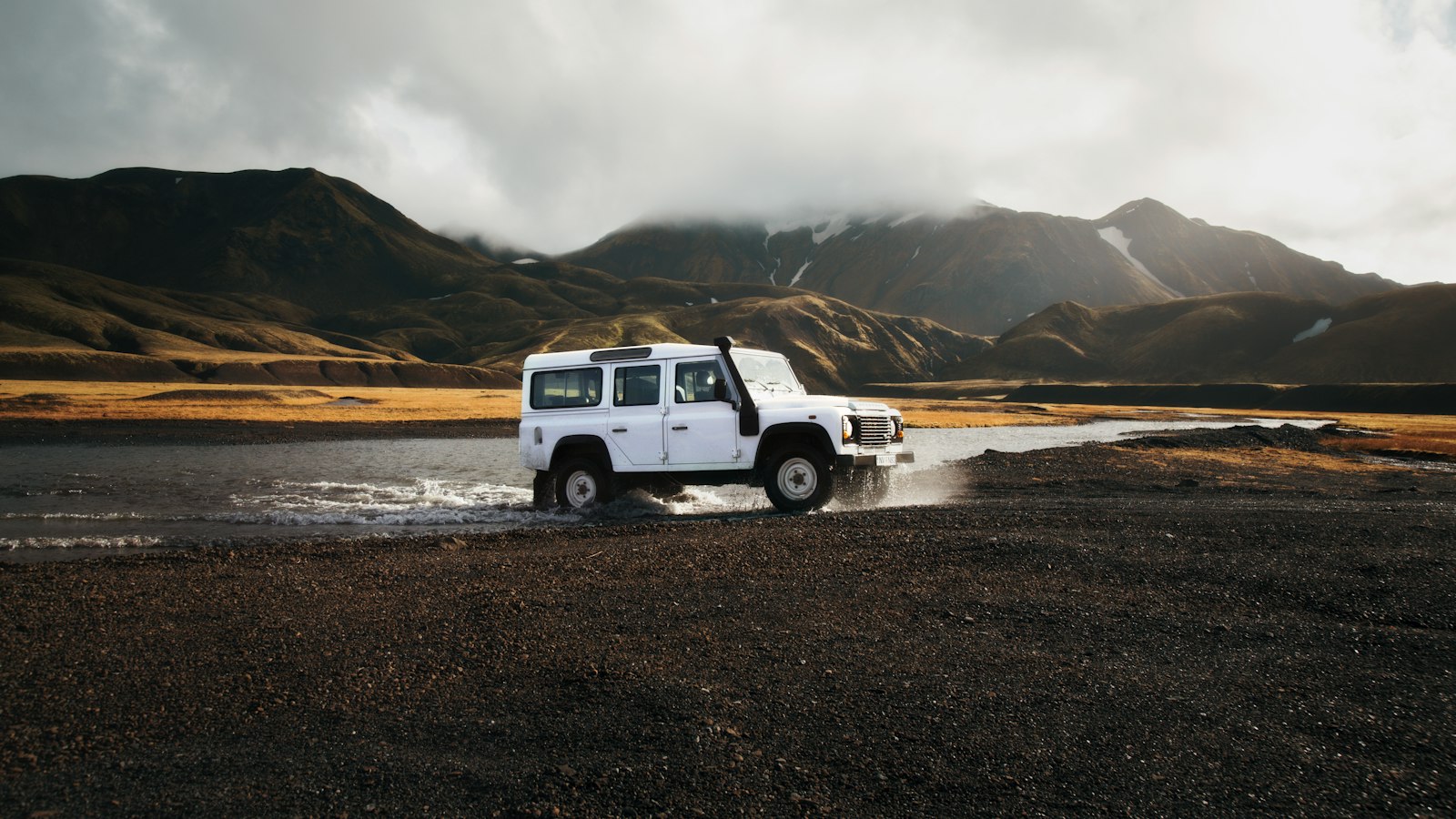 A four-wheel-drive crossing a highland river